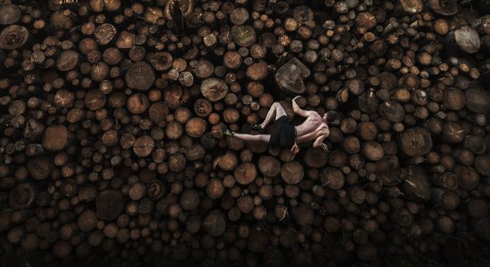 Der Münchener Boulding-Profi Georg Filser-Mayerhofer klettert in Kochel am See, Bayern, auf einen Holzstapel. Da während der Pandemie die Trainingshallen geschlossen sind, müssen sich die Sportlerinnen und Sportler kreative Trainingsmethoden überlegen., © Adam Pretty